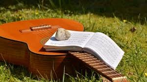 An open book on top of an acoustic guitar